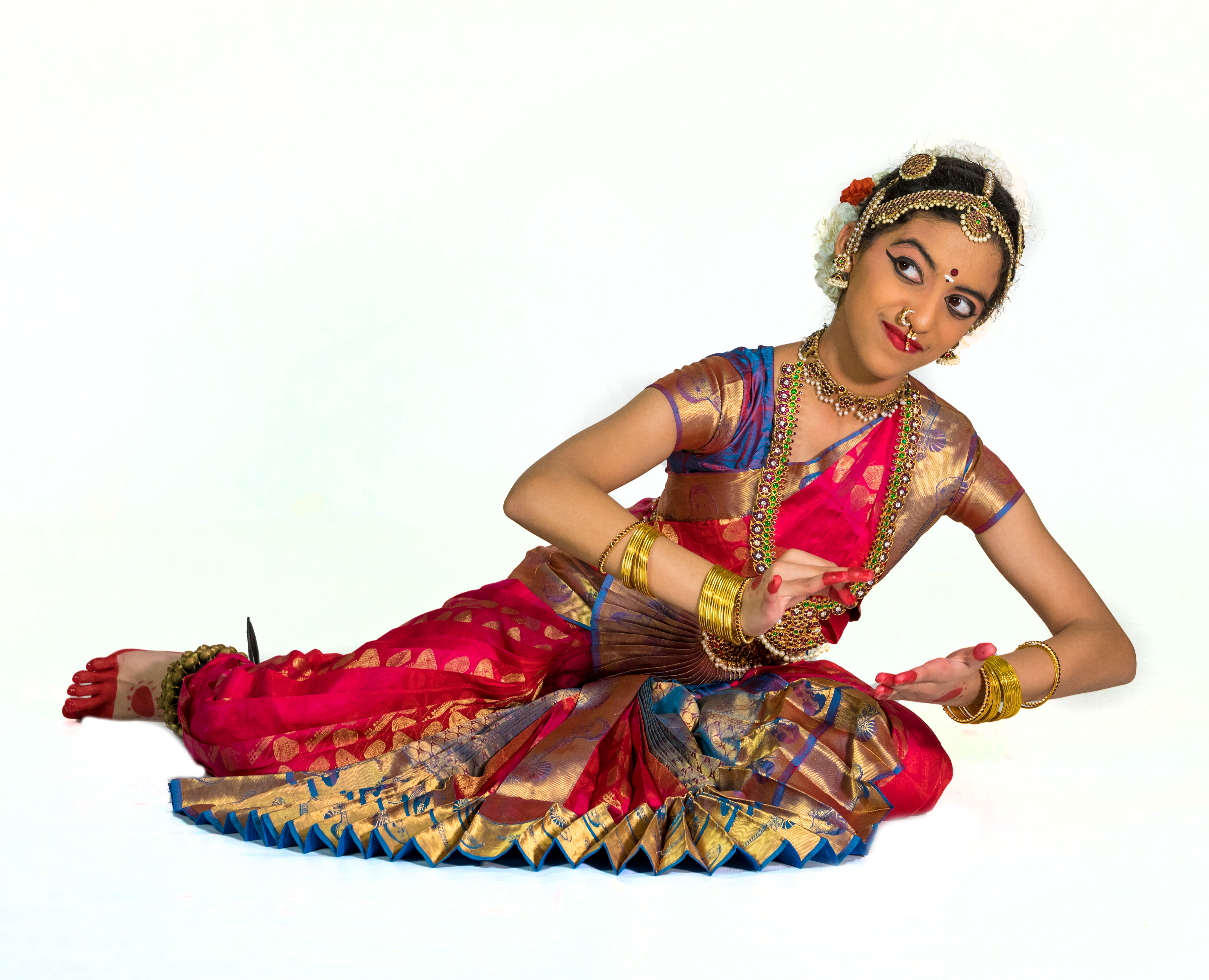 Aarushi Lakhi in a pink and blue Bharatanatyam costume showing writing