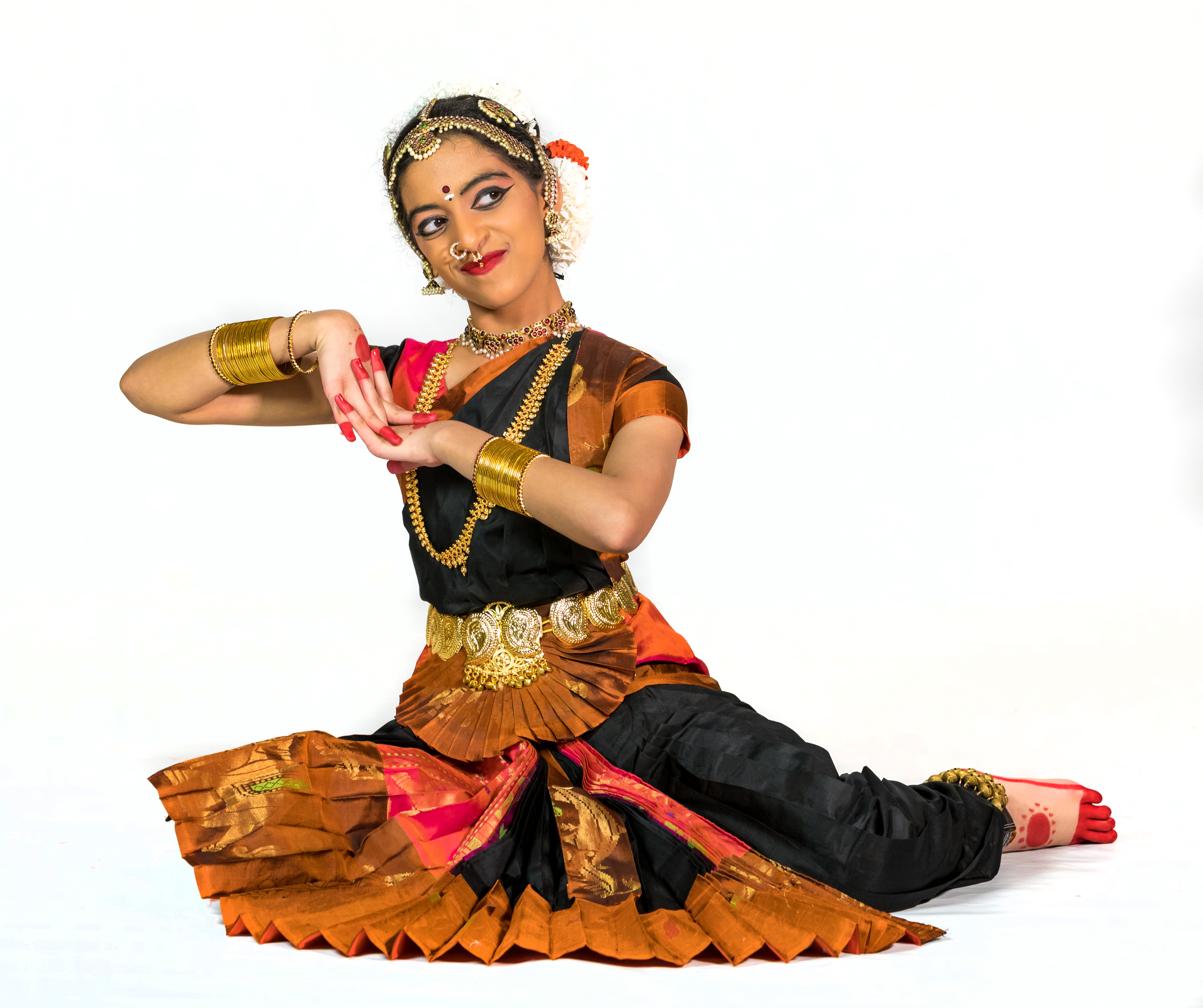 Aarushi Lakhi in a black and pink Bharatanatyam costume looking up smiling