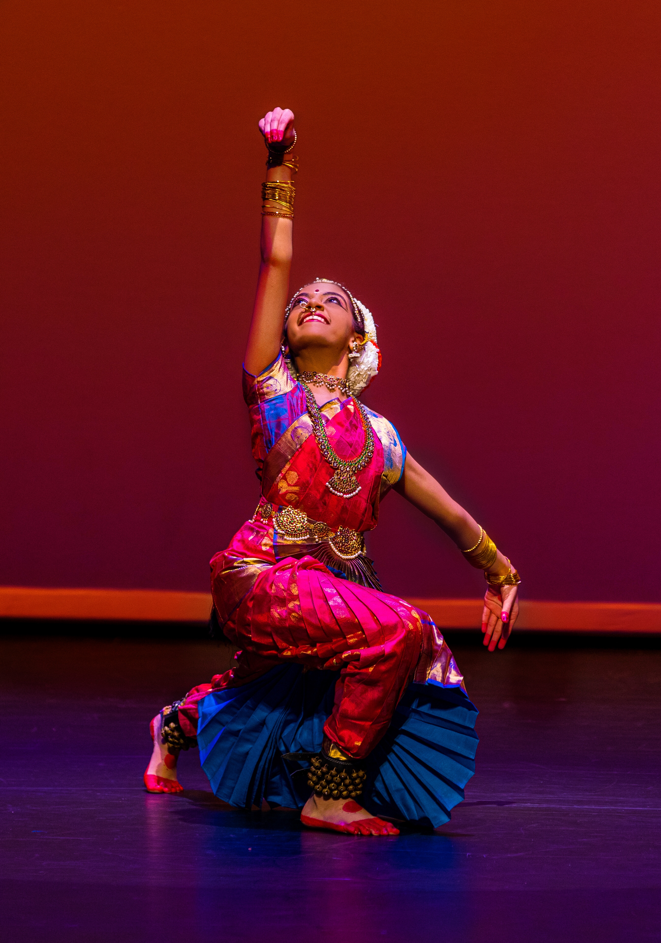 Aarushi Lakhi lunging, depicting Ganesha in a pink and blue Bharatanatyam costume